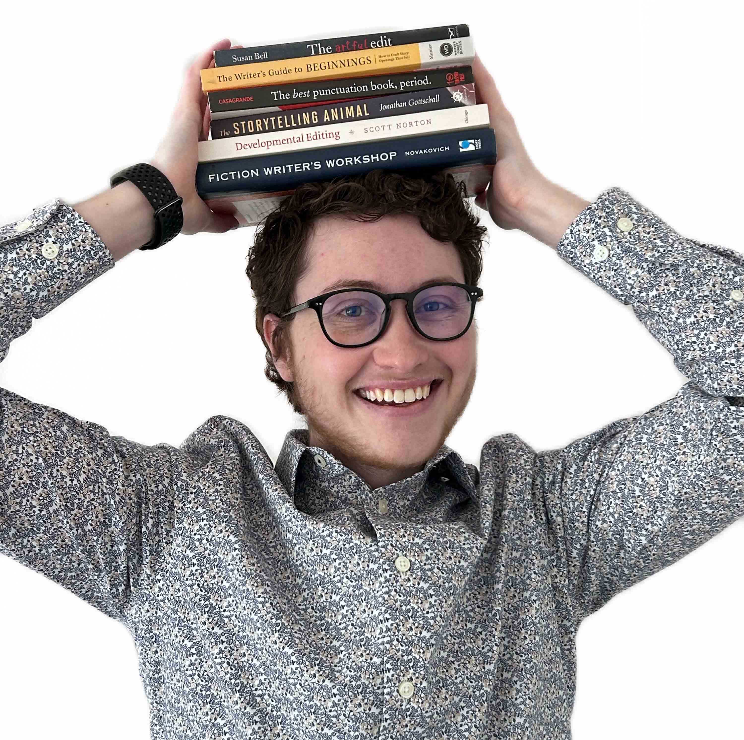 Mouse Larisheva, an adult white man with curly hair, holds books on his head.